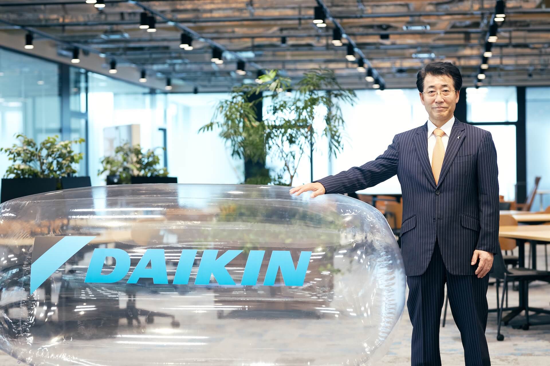 Katsuyuki Sawai beside the Daikin logo installation